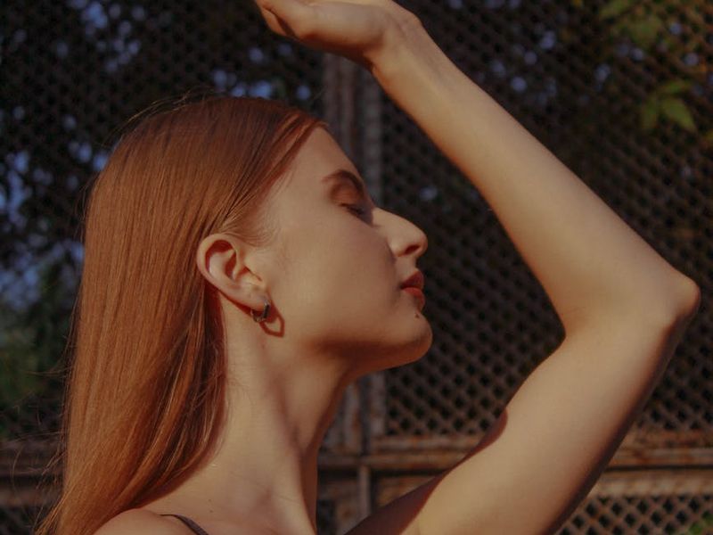 Person in a meditative pose in a quiet, sunlit space.